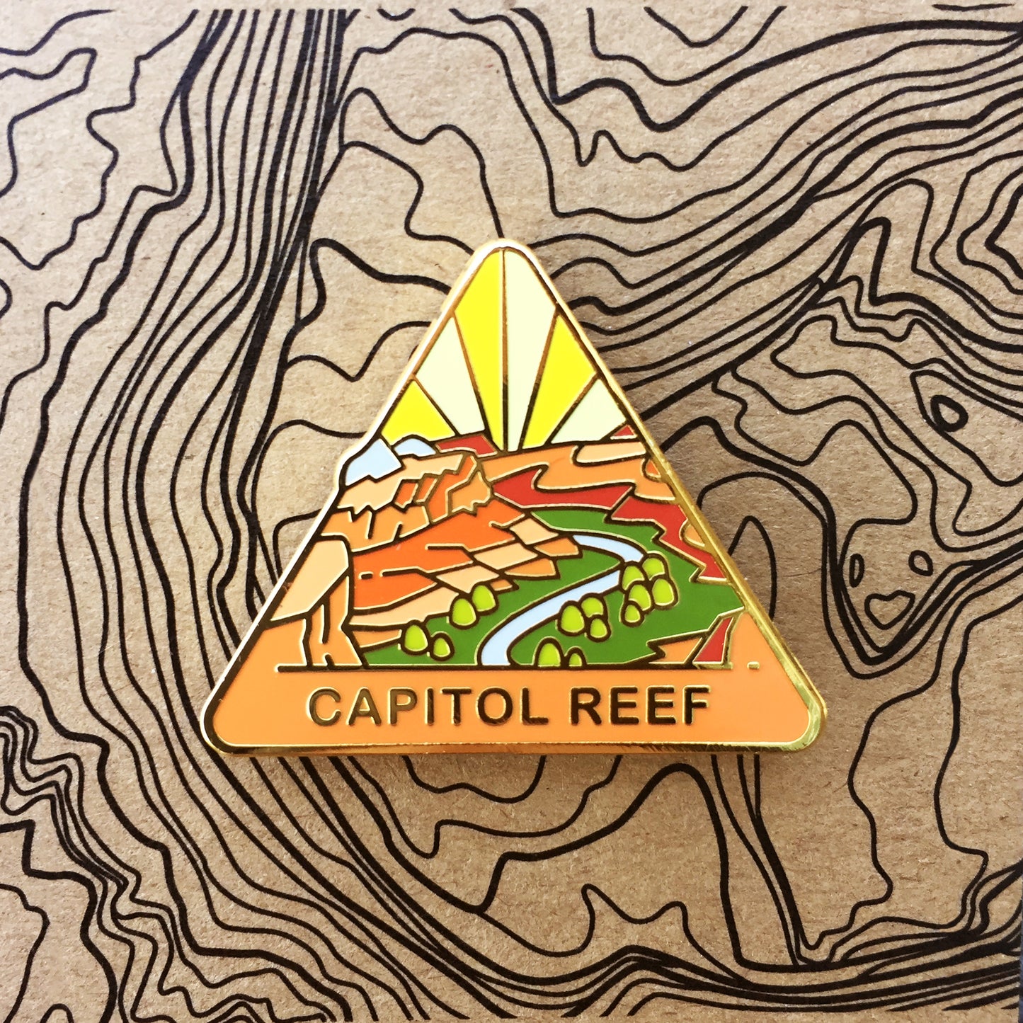 Triangle Capitol Reef national park enamel pin featuring a view from Navajo Knobs.