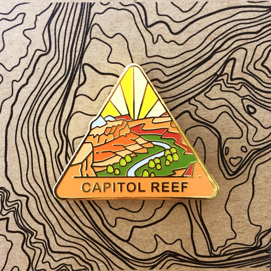 Triangle Capitol Reef national park enamel pin featuring a view from Navajo Knobs.