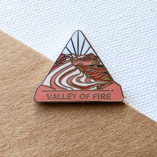 Valley of Fire triangle enamel pin featuring the breathtaking view from the Fire Wave with prominent streaks of red and white in the stone.