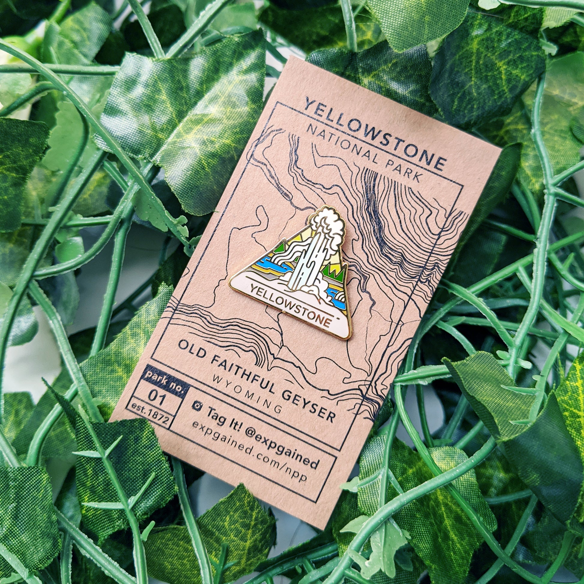 Triangle Yellowstone national park enamel pin featuring a view from the beehive hike on a brown business card size backing card with a topo map of Old Faithful Geyser location.