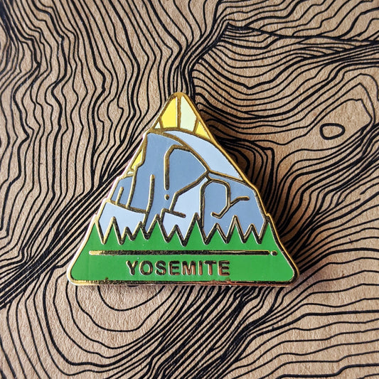 Triangle Yosemite national park enamel pin featuring a view of Half Dome from the valley floor.