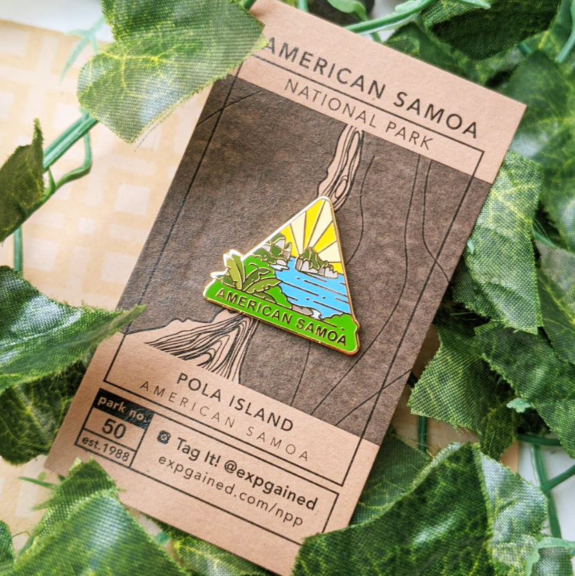 Triangle American Samoa national park enamel pin featuring a view from the beehive hike on a brown business card size backing card with a topo map of the Pola Island.