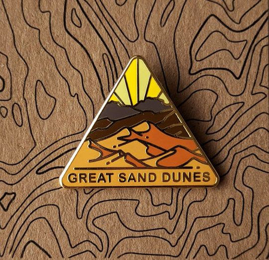 Triangle Great Sand Dunes national park enamel pin featuring a view of sand dunes.