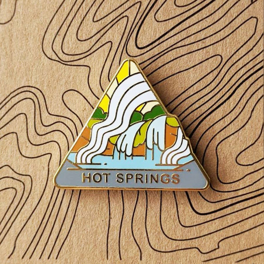 Triangle Hot Springs national park enamel pin featuring a view of hot springs in the downtown.