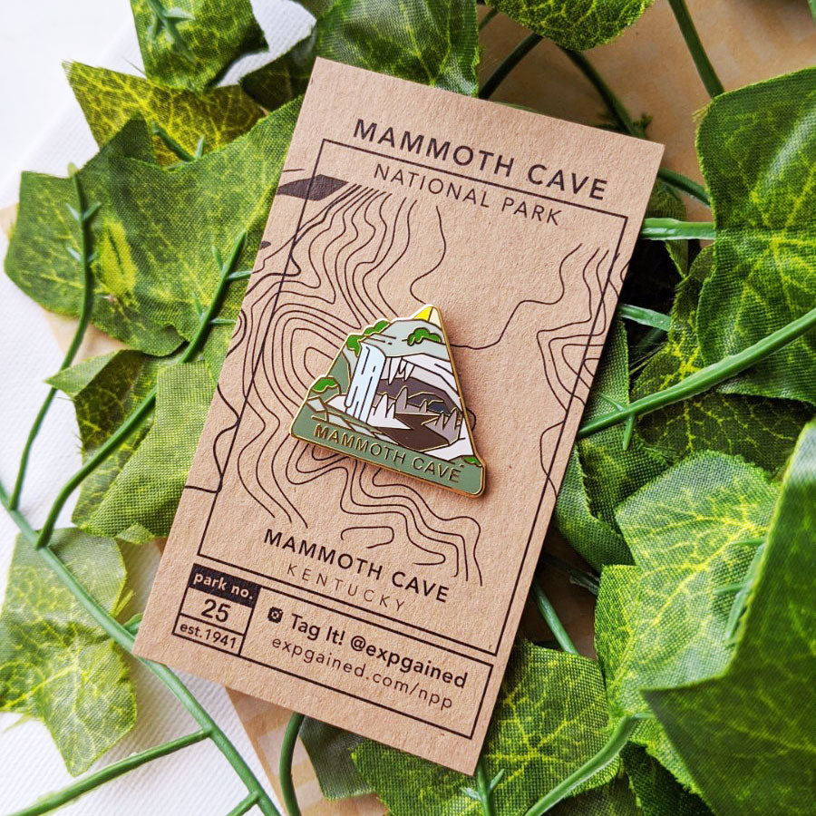 Triangle Mammoth Cave national park enamel pin featuring a view from the beehive hike on a brown business card size backing card with a topo map Mammoth Cave.