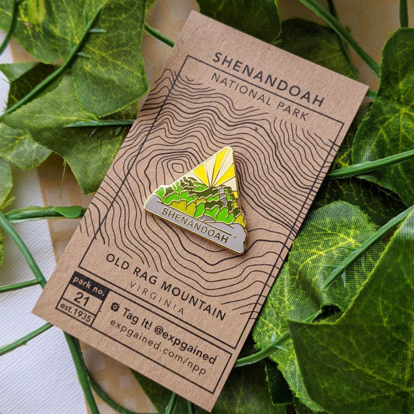 Triangle Shenandoah national park enamel pin featuring a view from the beehive hike on a brown business card size backing card with a topo map of Old Rag Mountain.