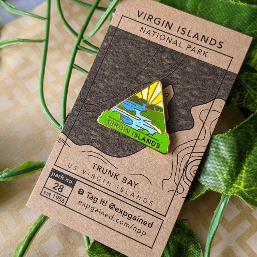 Triangle Virgin Islands national park enamel pin featuring a view from the beehive hike on a brown business card size backing card with a topo map of the Trunk Bay.
